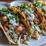 Zesty coconut lime marinated fish tacos served with vibrant slaw and tangy crema, perfect for a light summer meal.  