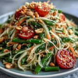 Crisp Som Tam salad featuring green papaya, peanuts, and zesty lime dressing.