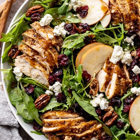 A rustic platter of Caramel Apple Chicken Salad showcases crisp red onion, candied pecans, and drizzled caramel-pecan dressing, ready for a cozy autumn main course.
