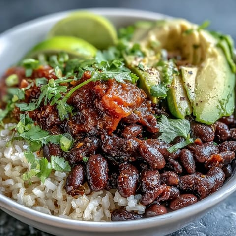 Vibrant plant-based taco bowl overflowing with seasoned black beans, fresh veggies, and salsa.