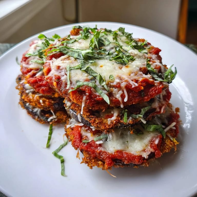 Cheesy, delicious view of Eggplant Parmesan, with perfectly baked layers and fresh basil garnish.