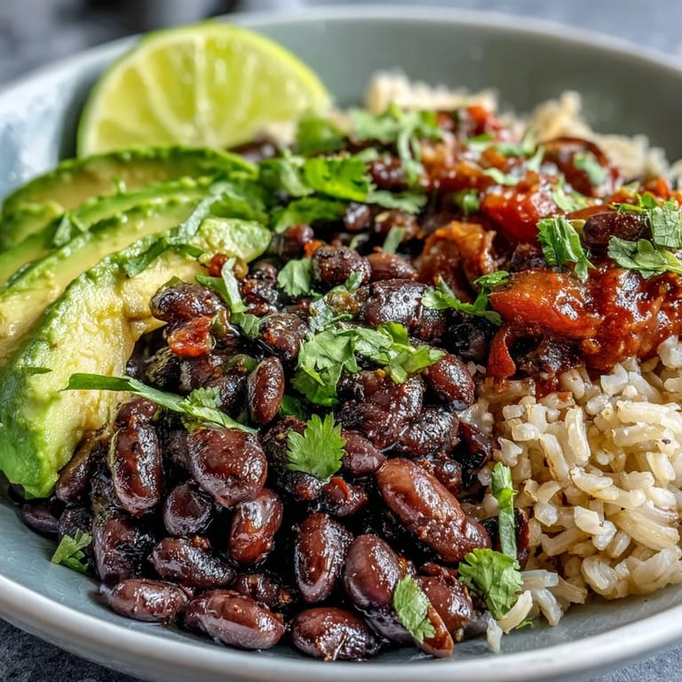 A satisfying plant-based taco bowl piled high with beans, corn, tomatoes, and lime.