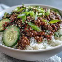 Fork-tender Korean Ground Beef Bowl with sesame-scented meat over fluffy white rice, topped with colorful quick-pickled carrots and cucumbers.